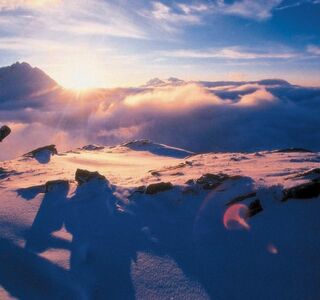 Snowboarder bei Sonnenaufgang