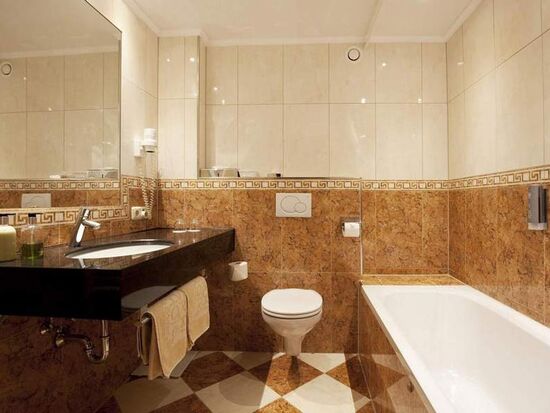 Elegantes Badezimmer mit Marmordetails, großer Badewanne und modernen Armaturen.