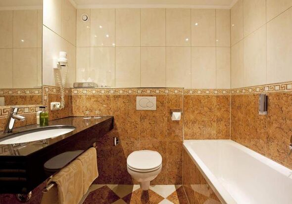 Modernes Badezimmer mit Badewanne, Waschbecken und stilvollen Fliesenwänden.