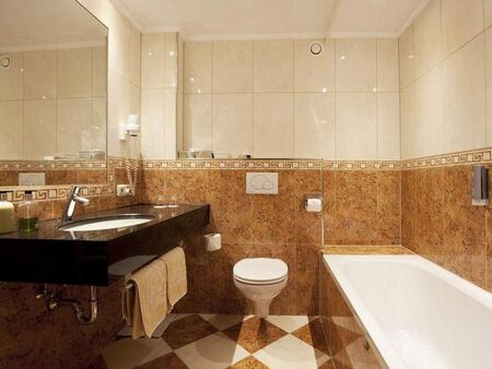 Elegantes Badezimmer mit Marmordetails, großer Badewanne und modernen Armaturen.