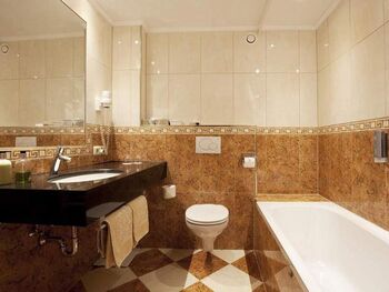 Elegantes Badezimmer mit Marmordetails, großer Badewanne und modernen Armaturen.