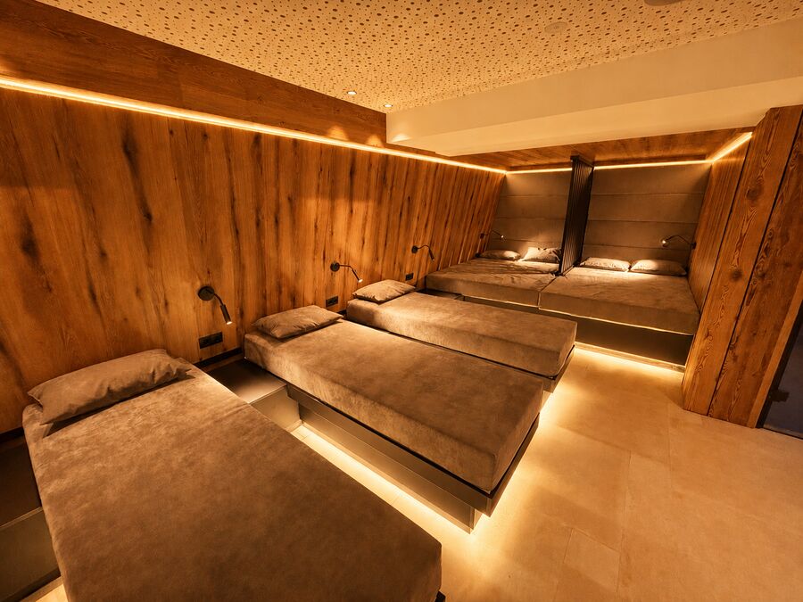 Holzverkleideter Ruheraum mit Liegen und Ambientebeleuchtung im Wellnessbereich des Sporthotels St. Anton
