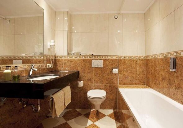 Elegantes Badezimmer mit Marmordetails, großer Badewanne und modernen Armaturen.