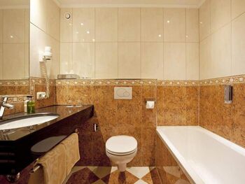 Modernes Badezimmer mit Badewanne, Waschbecken und stilvollen Fliesenwänden.